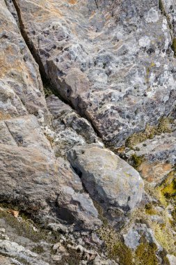 Bir adanın kayalık kıyılarında erozyon izleri var. Buzul kaynaklı göller.