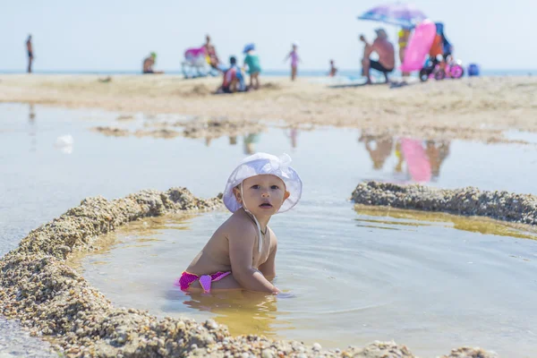 Het kind, een meisje op het strand is een zandkasteel, onderwijs en activiteiten voor kinderen, zomervakantie op zee zeegezicht, zee bruin waterbehandeling — Stockfoto