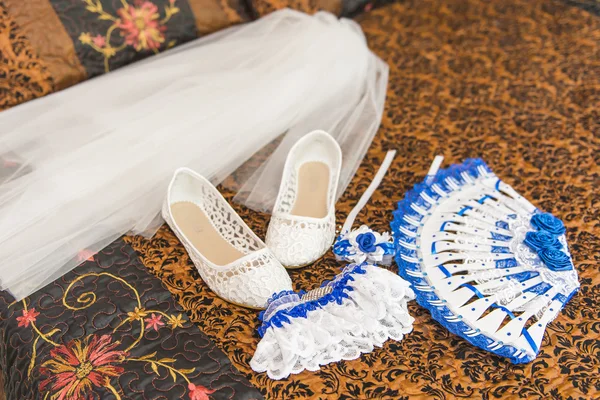 stock image Wedding bouquet and shoes of the bride. Garter, shoes, fan, veil bride on the bed.