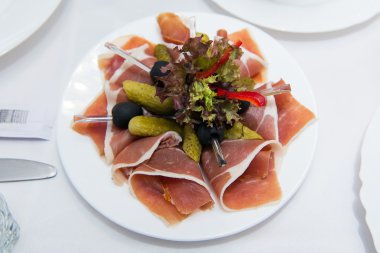 Pişmiş pastırma rashers beyaz bir arka plan üzerinde izole yakın çekim. Meze pastırma ve salatalık turşusu