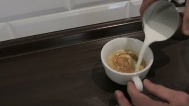 Profesyonel barista meşgul bir kafede bir kapuçino dökme