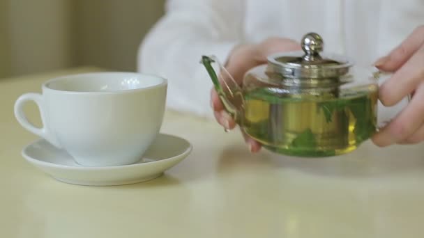 Vrouw giet groene thee theepot — Stockvideo