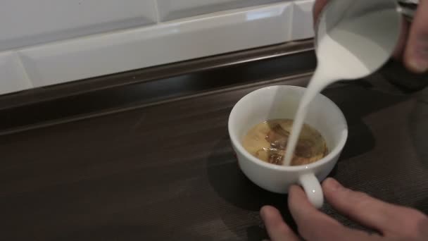 Barista profesional menuangkan cappuccino di sebuah kedai kopi yang sibuk — Stok Video