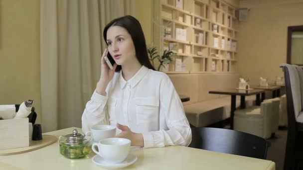 Junge Frau trinkt Tee in einem Café — Stockvideo