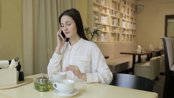 카페에서 휴대폰에 말하는 젊은 여자 — 비디오