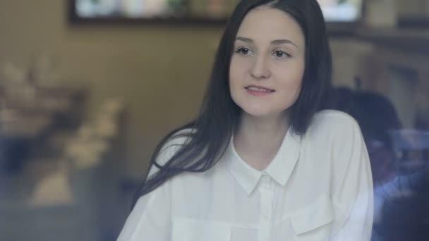 Junge Frau trinkt Tee in einem Café — Stockvideo