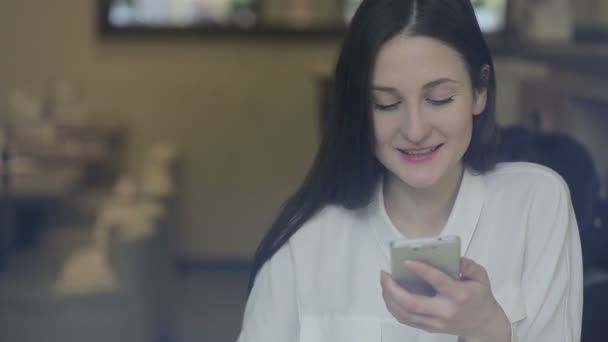 Jonge vrouw praten over cellphone in café — Stockvideo