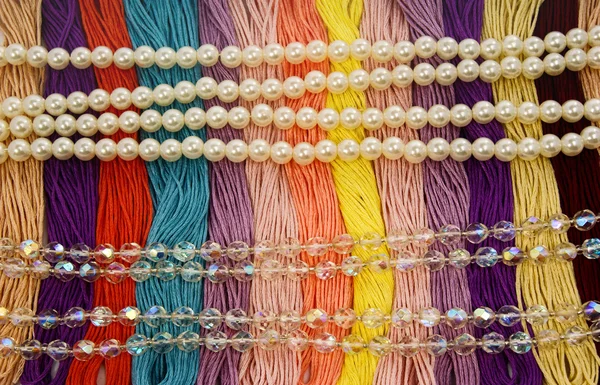 Різнокольорові нитки. Фланець з красивими різнокольоровими перлами і скляними намистинами блискучий, креативний і вишитий . — стокове фото