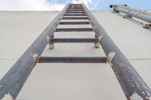 Vieja escalera de hierro hasta el cielo azul con nube — Foto de Stock
