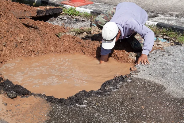 Male workers repair pipe water main broken — Stock Photo, Image