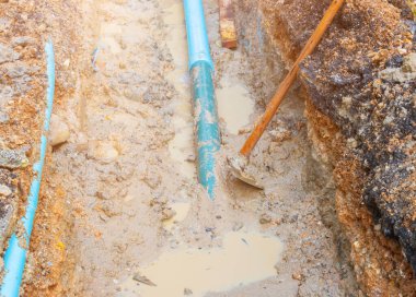 Tesisatçı ana boru tesisatını tamir ediyor.