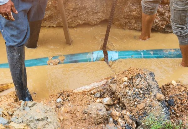 Tesisatçı su hattını tamir ediyor.