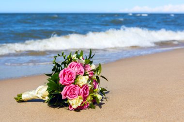 Gelinin düğün çiçeği denizin arka planında..