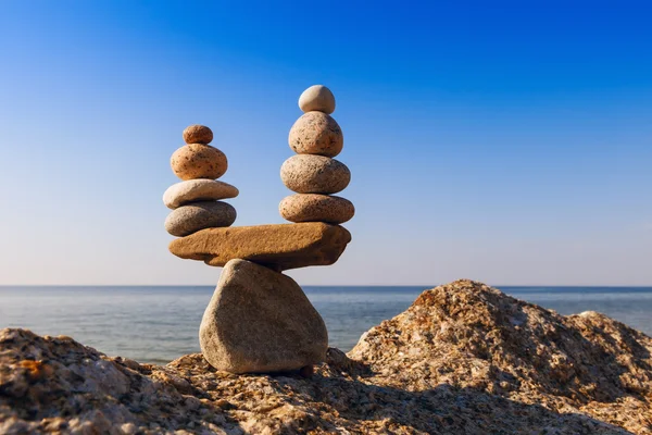 Konzept der Harmonie und Ausgewogenheit. Steine gegen das Meer balancieren. — Stockfoto