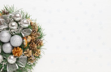 Beyaz arka planda Noel çelengi, gümüş toplar ve köknar dalları. Yeni yıl dekorasyonları, üst görünüm, kopyalama alanı