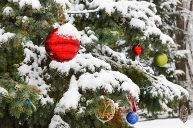 Karda renkli toplarla süslenmiş Noel ağacı