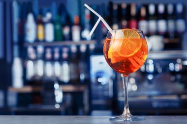 Parlak bar tezgahında turuncuyla süslenmiş Aperol kokteyli. Yumuşak odaklı, seçici odaklı