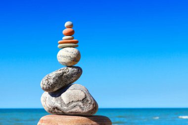 Denizin arka planında gri ve kırmızı zen taşları. Uyum, denge ve meditasyon kavramı.