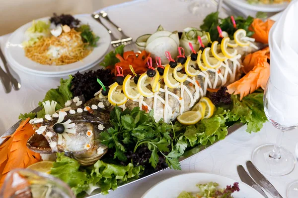 Stuffed pike decorated with lemons on a festive table. Soft focus, selective focus — Stock Image Stuffed Pike Decorated Lemons Festive Table Soft Focus Selective Focus Stock Photo
