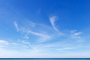Denizin üzerindeki güzel mavi gökyüzü şeffaf, beyaz, Cirrus bulutlarıyla. Ufuk çizgisi