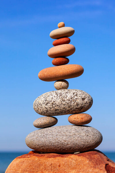 Rock zen pyramid of colorful stones on the beach. Concept of Life balance, harmony and meditation