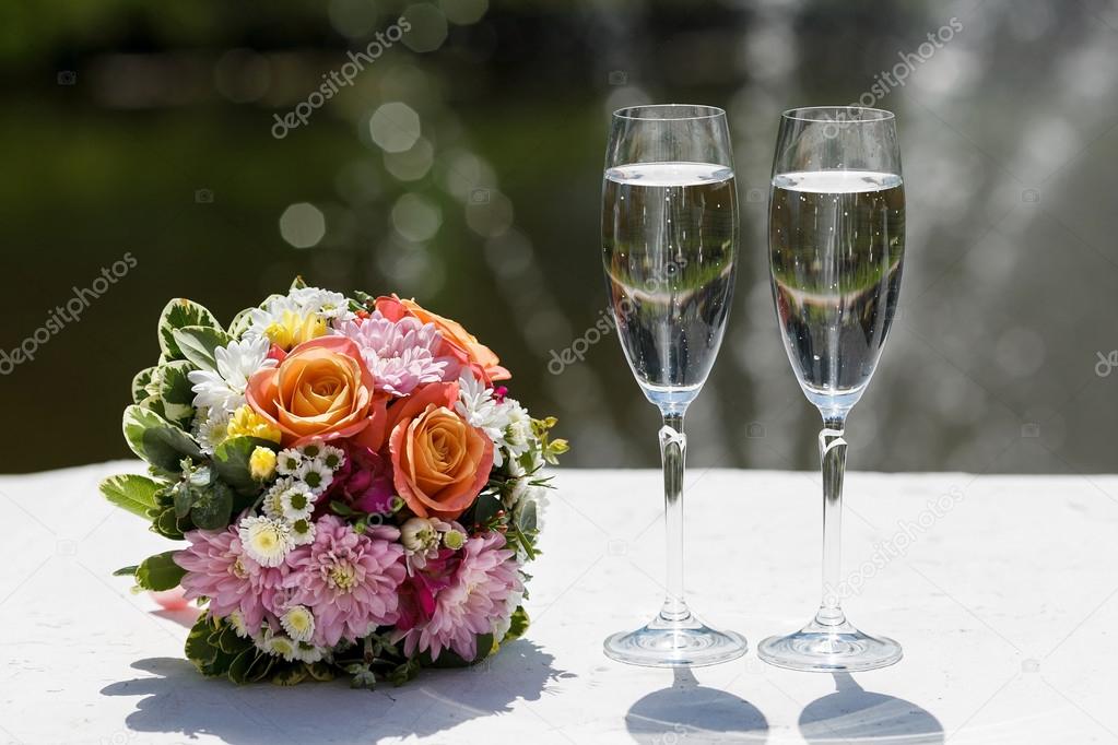 two glasses of sparkling wine and bouquet of the bride