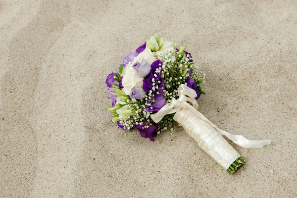 Buquê de noiva deitado na areia — Fotografia de Stock