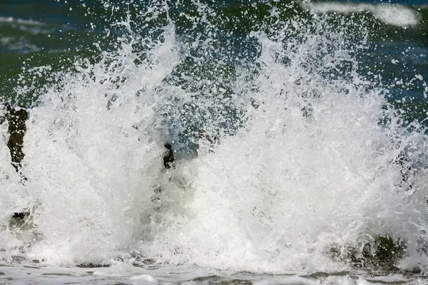 Onde del mare che si infrangono sul frangiflutti . — Foto Stock