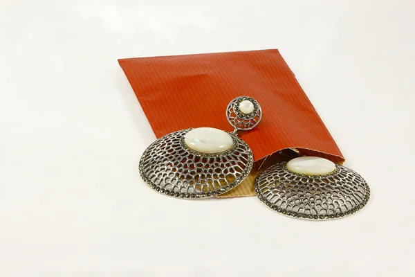 Серебряные серьги и красный конверт — стоковое фото