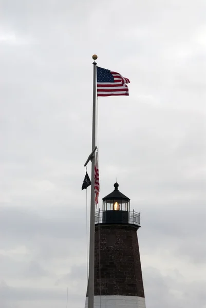 Bandeira americana acenando sobre o farol — Fotografia de Stock