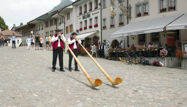 Gruyere, İsviçre - 19 Temmuz 2014. İsviçre müzisyenler halk Ulusal müzik aleti alphorn Gruyere köyde oynamak..