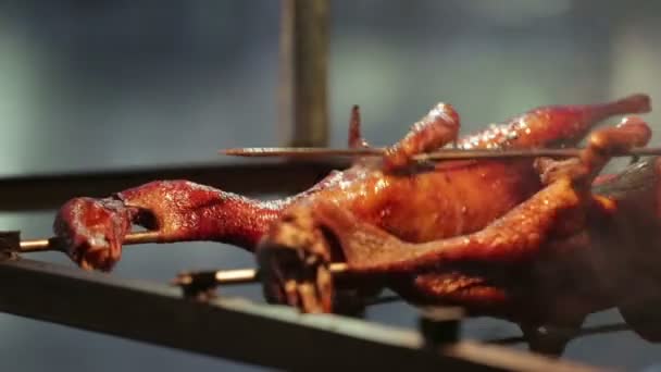 Two roast ducks spinning on the skewers. Street meal in Asia — Stock Video