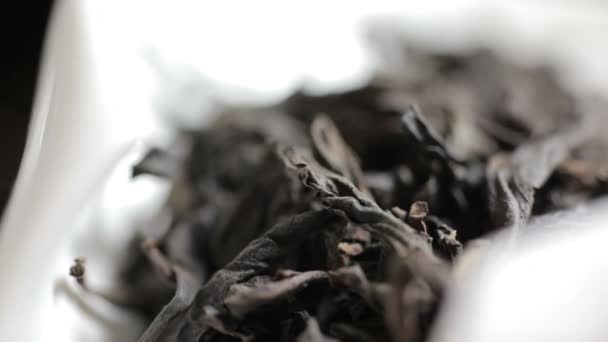 Primo piano colpo di aromatico nero sciolto tè foglie pila su sfondo chiaro — Video Stock