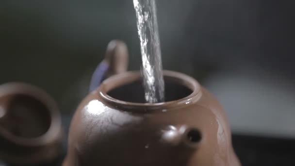 Water pouring into earthenware teapot — Stock Video