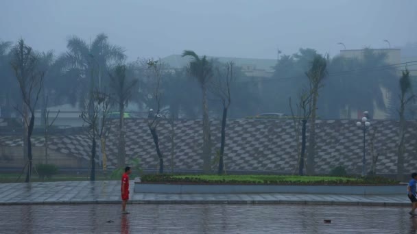 ハノイ, ベトナム - 2015 年 3 月 13 日: 雨の中の少年がフットボール (サッカー) — ストック動画