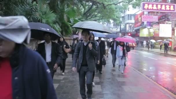 Cina, Hong Kong - 04 marzo 2015: La gente sotto la pioggia cammina per strada — Video Stock