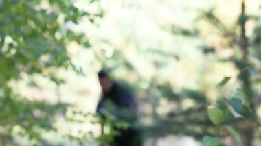 adam çalılıkların arasından biterse ve kamera hedefliyor