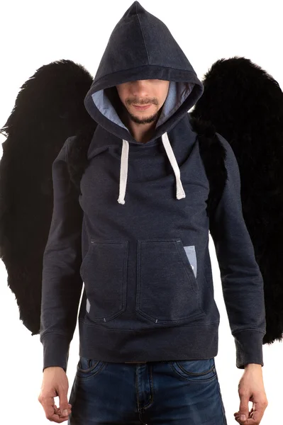 başının üzerinde bir başlık atılmış gri ceketli adam gülümseyerek ve elleri sırtında ve büyük siyah kanatları ile ayakta