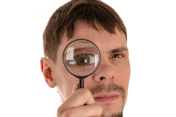 Hombre mirando a través de una lupa ojo gigante — Foto de Stock