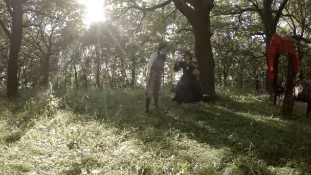 Junger Mann wirft Frau im Vintage-Kleid auf Schaukel — Stockvideo