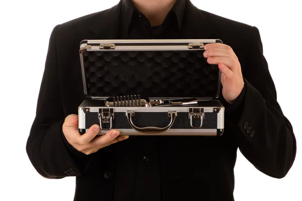 Homme dans une veste noire et une chemise noire garde un boîtier en métal ouvert avec un microphone à l'intérieur Images De Stock Libres De Droits