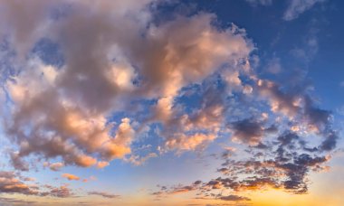 Pembe ve turuncu bulutlar günbatımında sihirli bir şekilde nehrin üzerinde yüzerler. Seddin yanında, sakin, pofuduk bir gökyüzü manzarası. Yatmadan önce yürüyüş, akşamları doğanın tadını çıkarmak. Suda sarı güneş yansıması.