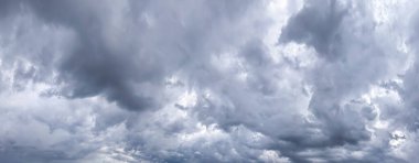 Gökyüzü ve kara bulut. Arka planda yağmur bulutları olan güneşli, mavi bir gökyüzü. Geniş pankart için gri doku.