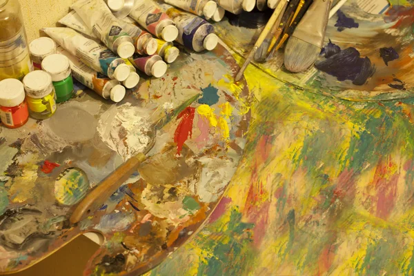 Arbetsplatsen målare, pensel i handen, burkar med gouache, duk för — Stockfoto