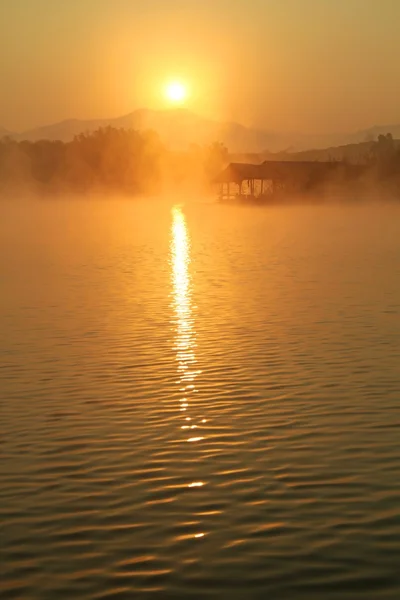 Misty tropical sunset on lake with wooden house in Mae Ngad Dam and Reservoir, Chiang Mai, Thailand — Stock Photo, Image