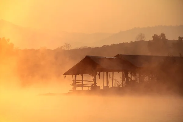 Puesta de sol tropical brumosa en el lago con casa de madera en la presa y embalse de Mae Ngad, Chiang Mai, Tailandia — Foto de Stock