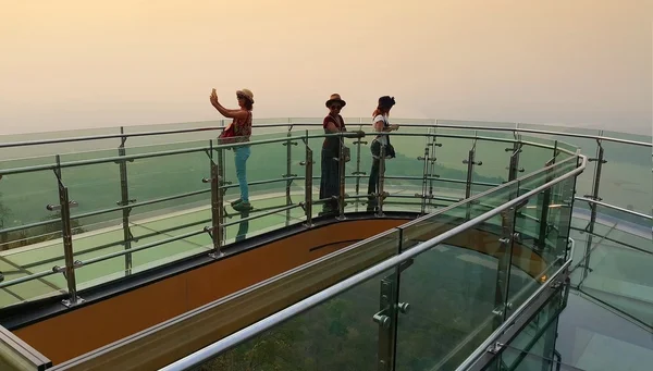 Província de Nong Khai, Tailândia - 28 de abril de 2016: Turistas caminhando e Selfie no céu transparente caminham para ver a vista do rio Mekong durante o pôr do sol em Wat Pha Tak Suea, distrito de Sangkhom, província de Nong Khai , — Fotografia de Stock