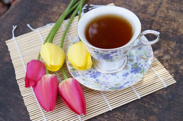 Tazza da tè, fiore di tulipano, su sfondo di legno — Foto Stock