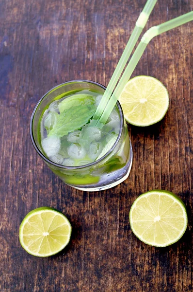 Acqua di disintossicazione nutriente con lime e menta in un bicchiere sullo sfondo di legno — Foto Stock