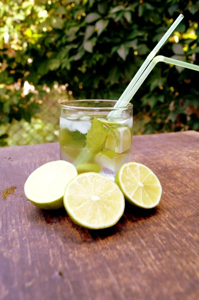 Agua desintoxicante nutritiva con cal y menta en un vaso sobre el fondo de madera —  Fotos de Stock